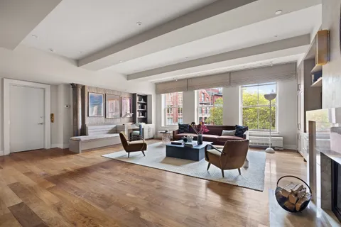 a living room with furniture large window and a fireplace