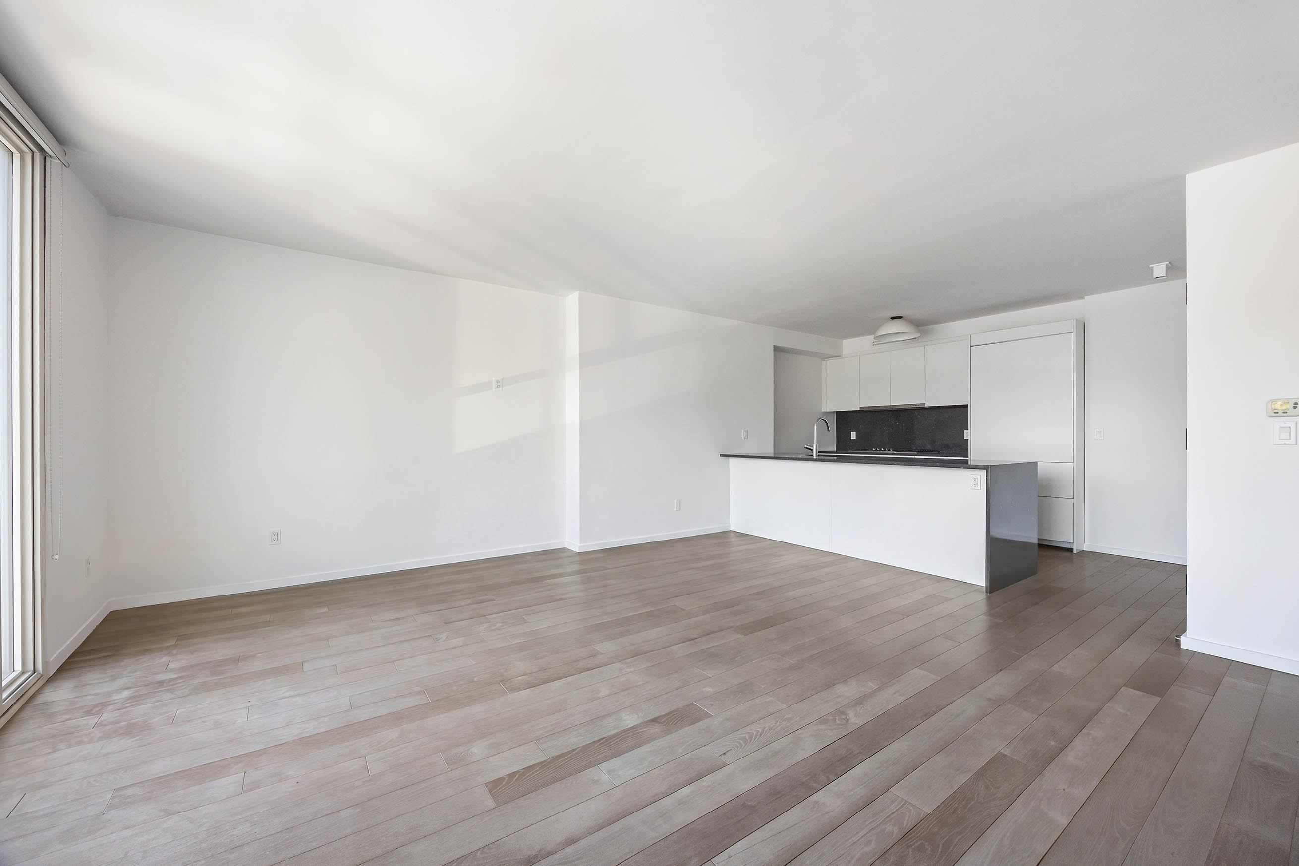 385 1st Avenue, Unit 10A Manhattan, NY 10010 - Photo 4 of 9 a view of a kitchen with wooden floor and electronic appliances