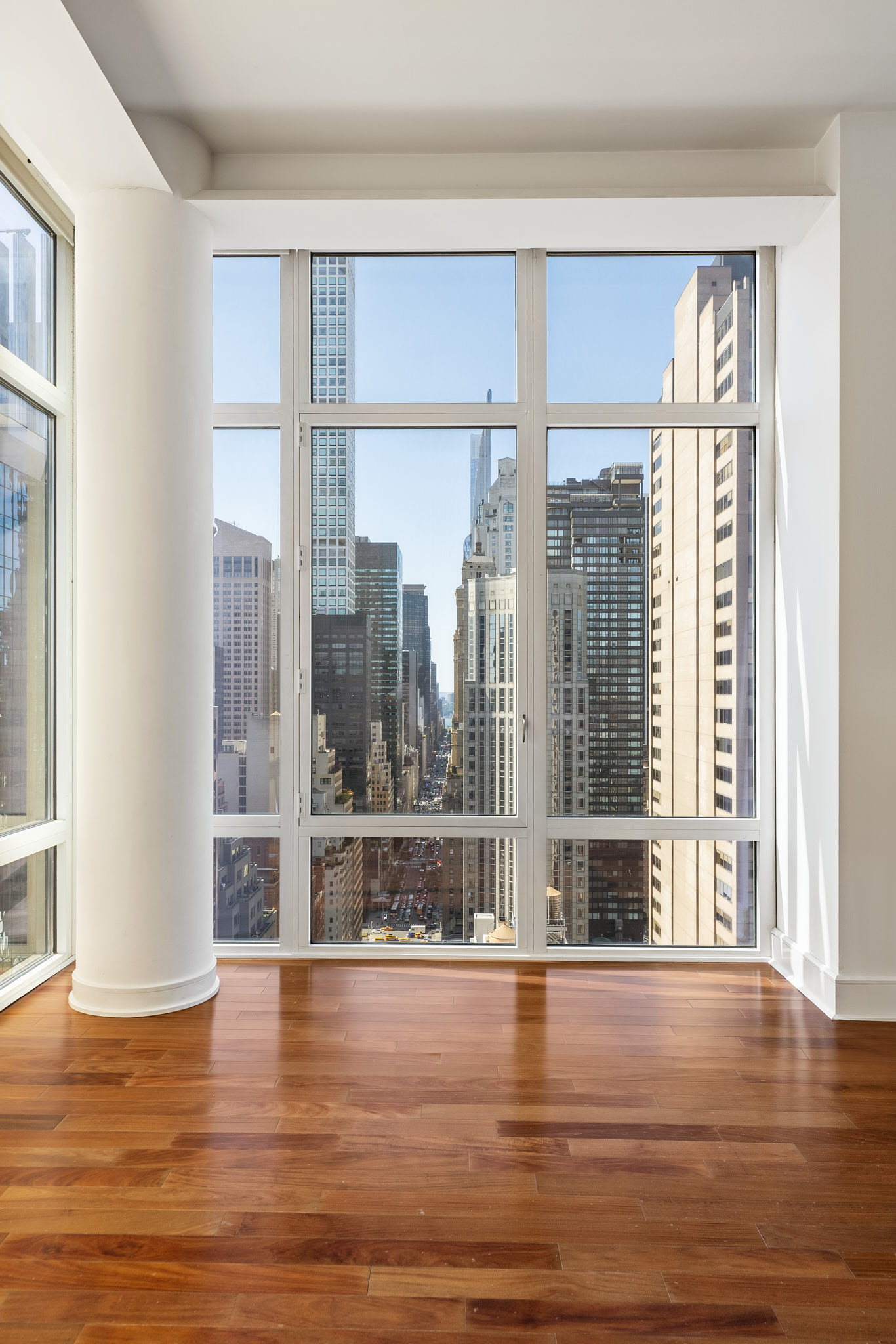 207 East 57th Street, Unit 33B Manhattan, NY 10022 - Photo 3 of 8 a view of a livingroom with wooden floor and a window