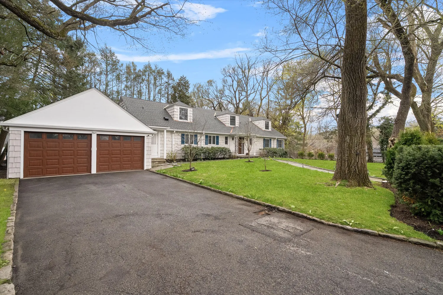 a view of a house with a yard and large tree