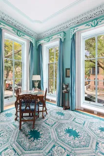 a dining room with wooden floor and a rug