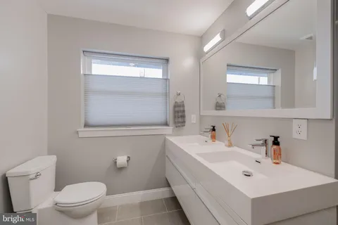 a bathroom with a sink a toilet and a mirror