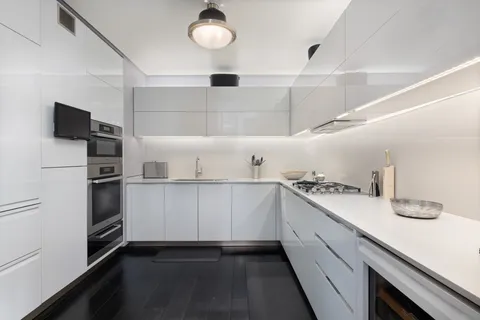 a kitchen with white cabinets and appliances