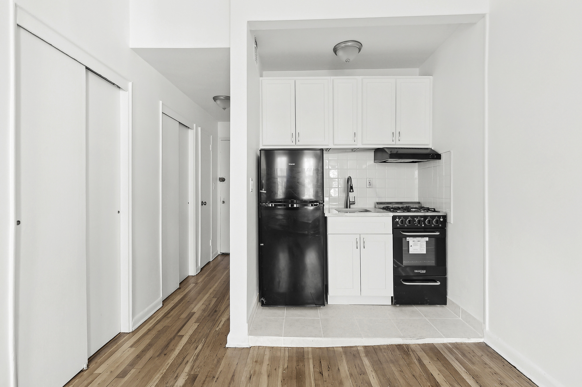 313 East 89th Street, Unit 4F Manhattan, NY 10128 - Photo 2 of 5 a view of a kitchen with refrigerator and wooden floor
