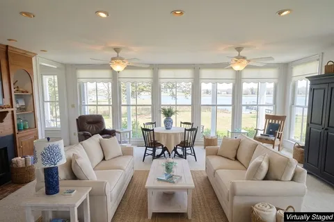 a living room with furniture a large window and a fireplace