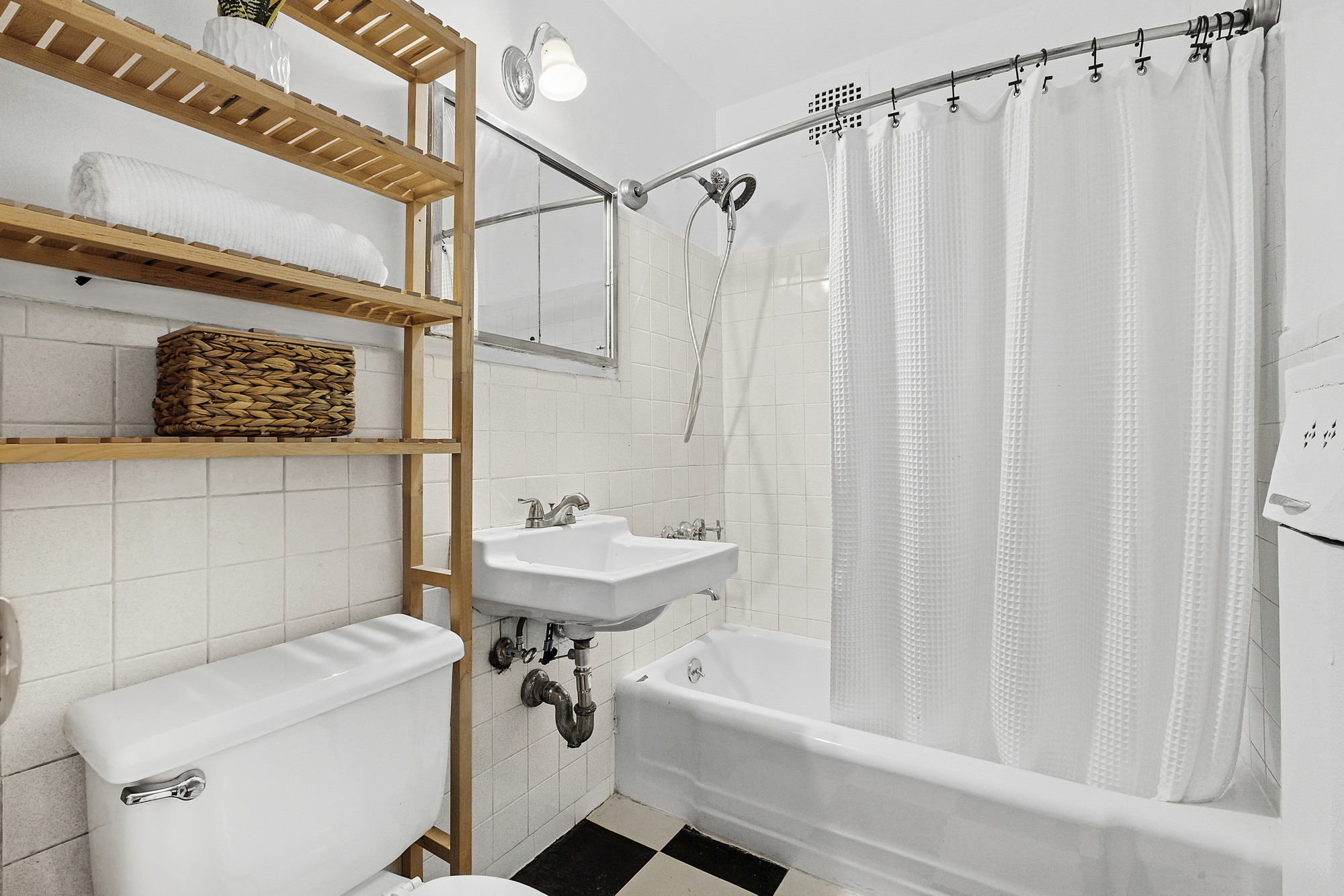 195 Willoughby Avenue, Unit 905 Brooklyn, NY 11205 - Photo 6 of 7 a bathroom with a sink a toilet and shower curtain