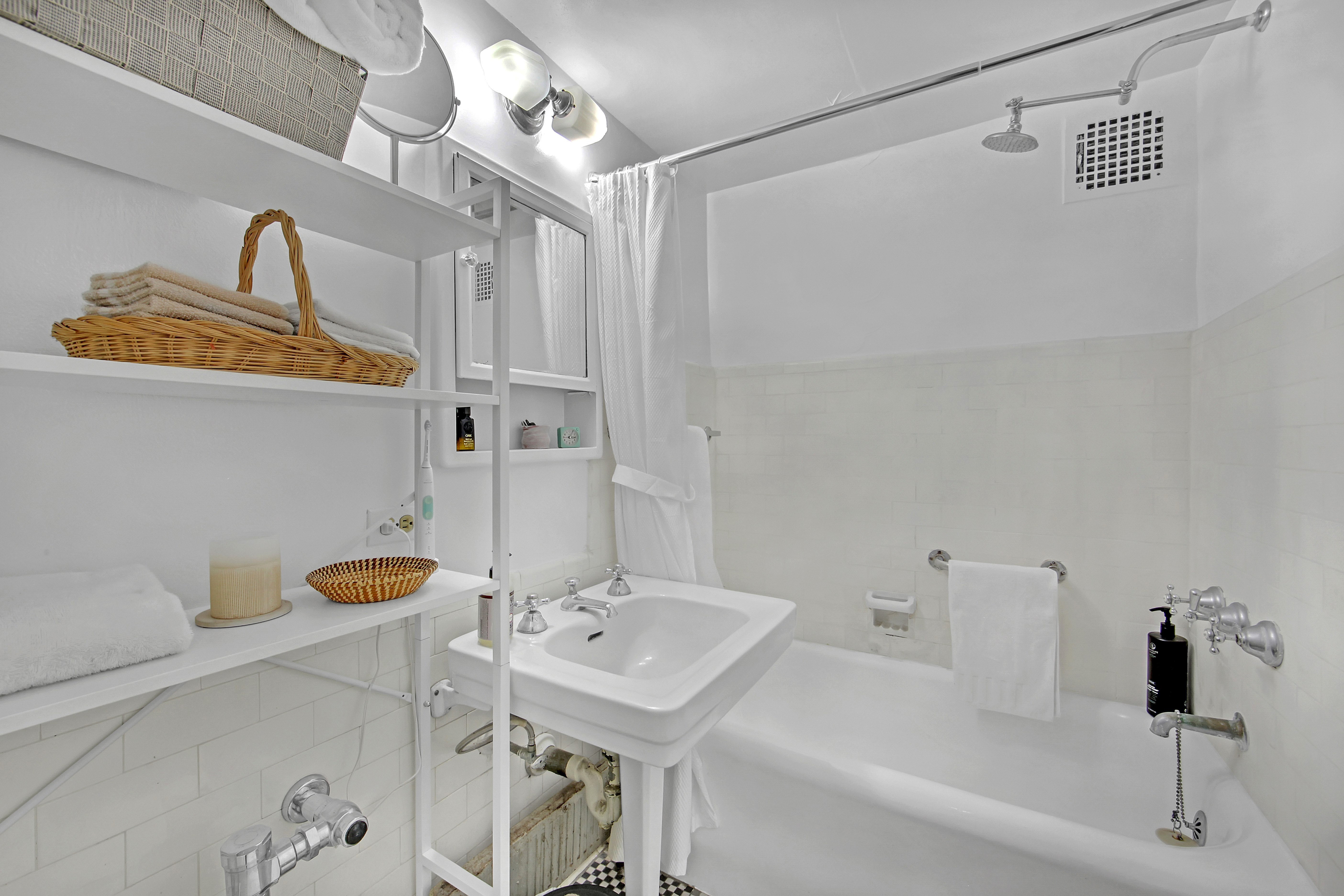 5 Tudor City Place, Unit 539 Manhattan, NY 10017 - Photo 11 of 12 a bathroom with a sink and a mirror