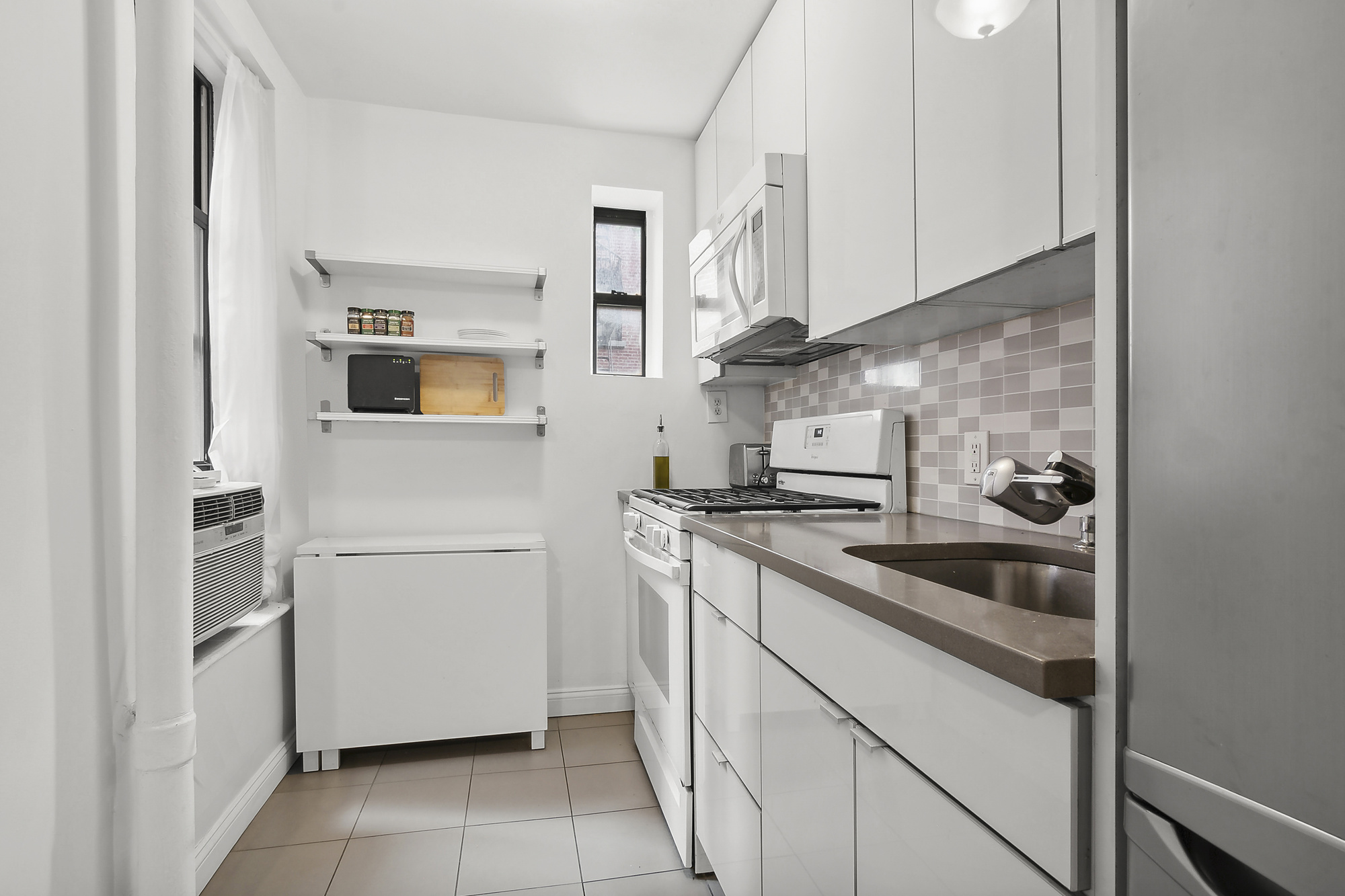 439 Hicks Street, Unit 2C Brooklyn, NY 11201 - Photo 3 of 7 a kitchen with stainless steel appliances granite countertop white cabinets and white appliances