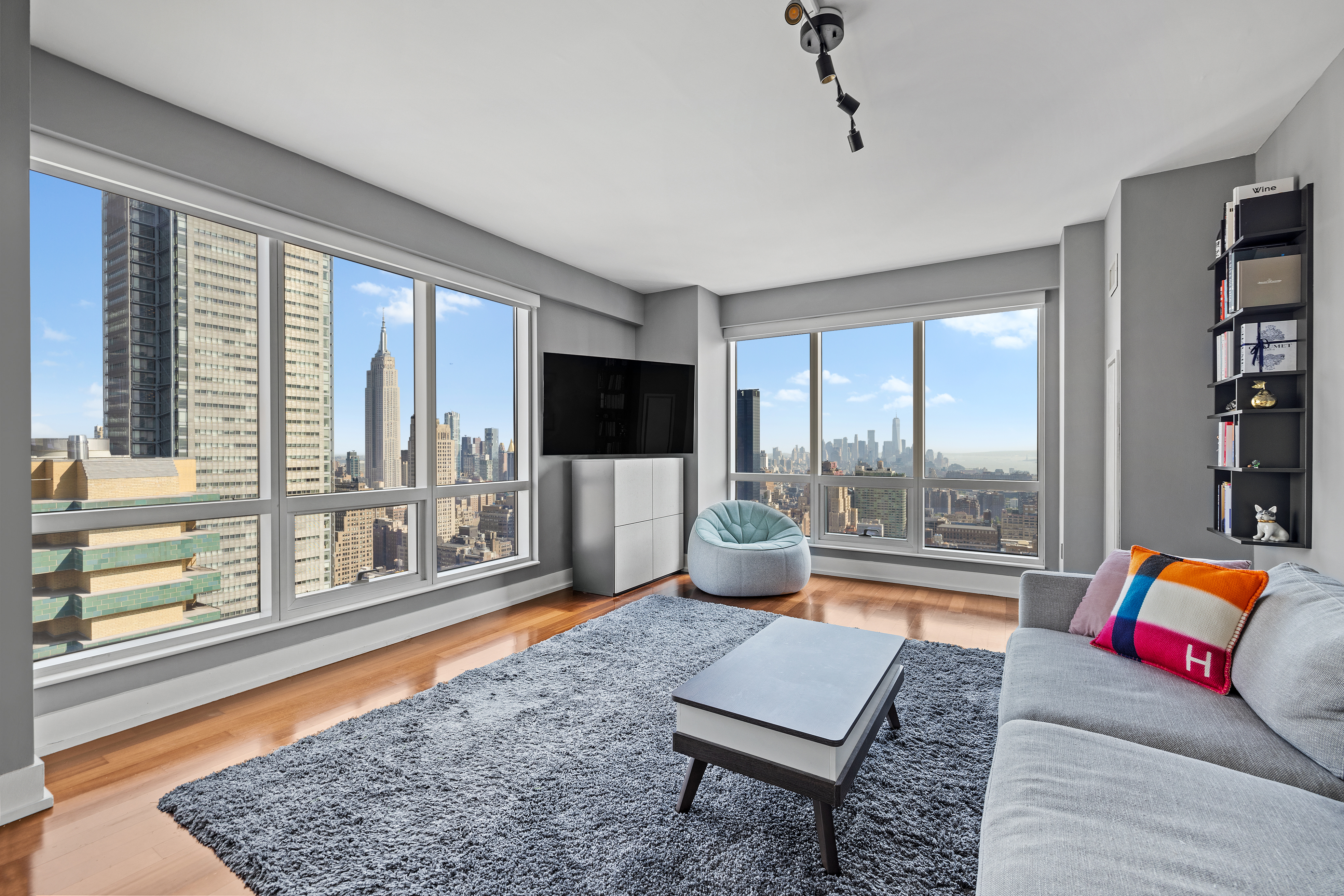 350 West 42nd Street, Unit 50E Manhattan, NY 10036 - Photo 1 of 9 a living room with furniture and a floor to ceiling window