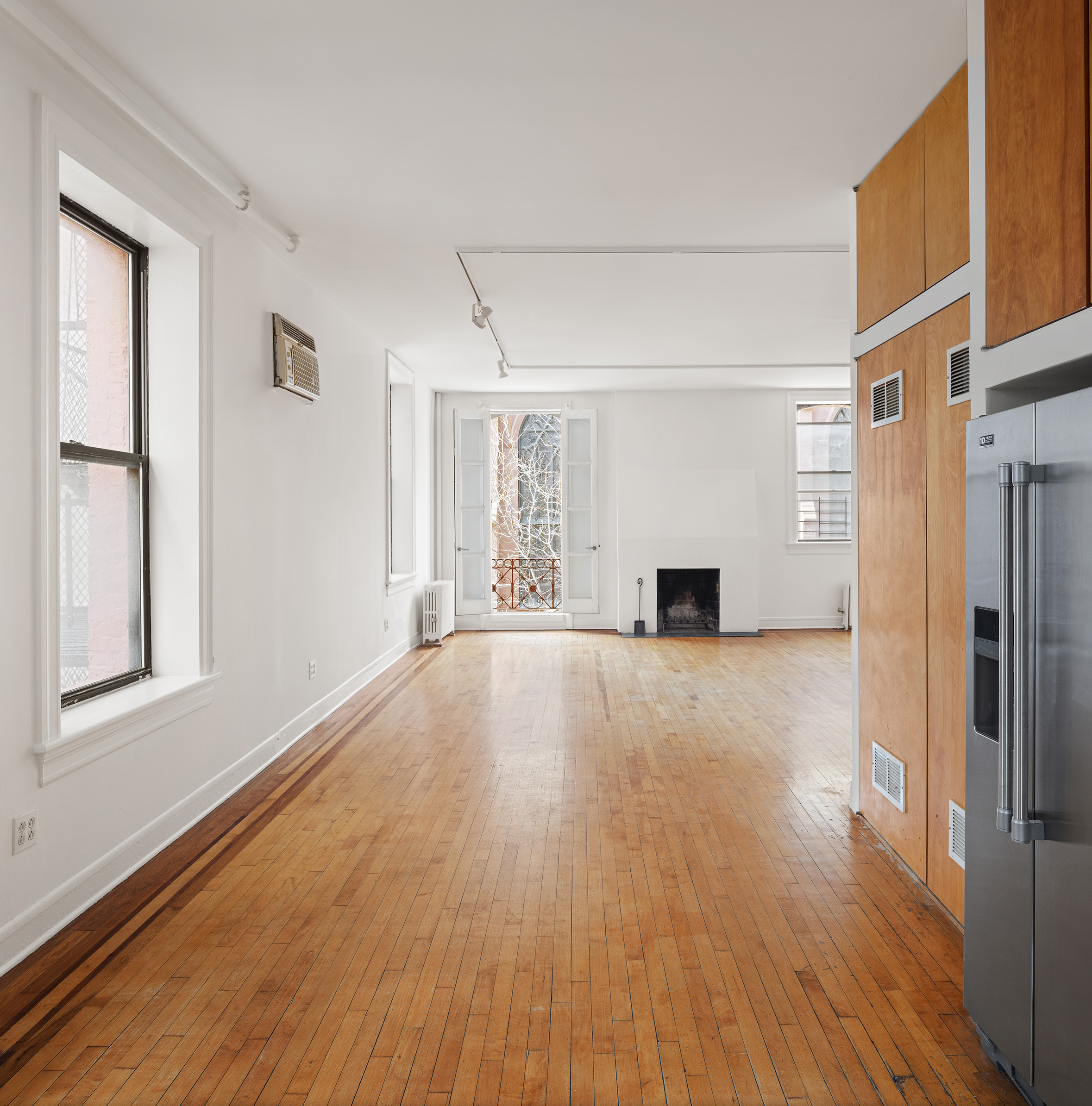 295 East 8th Street, Unit 2/3E Manhattan, NY 10009 - Photo 10 of 23 a view of a big room with wooden floor and windows