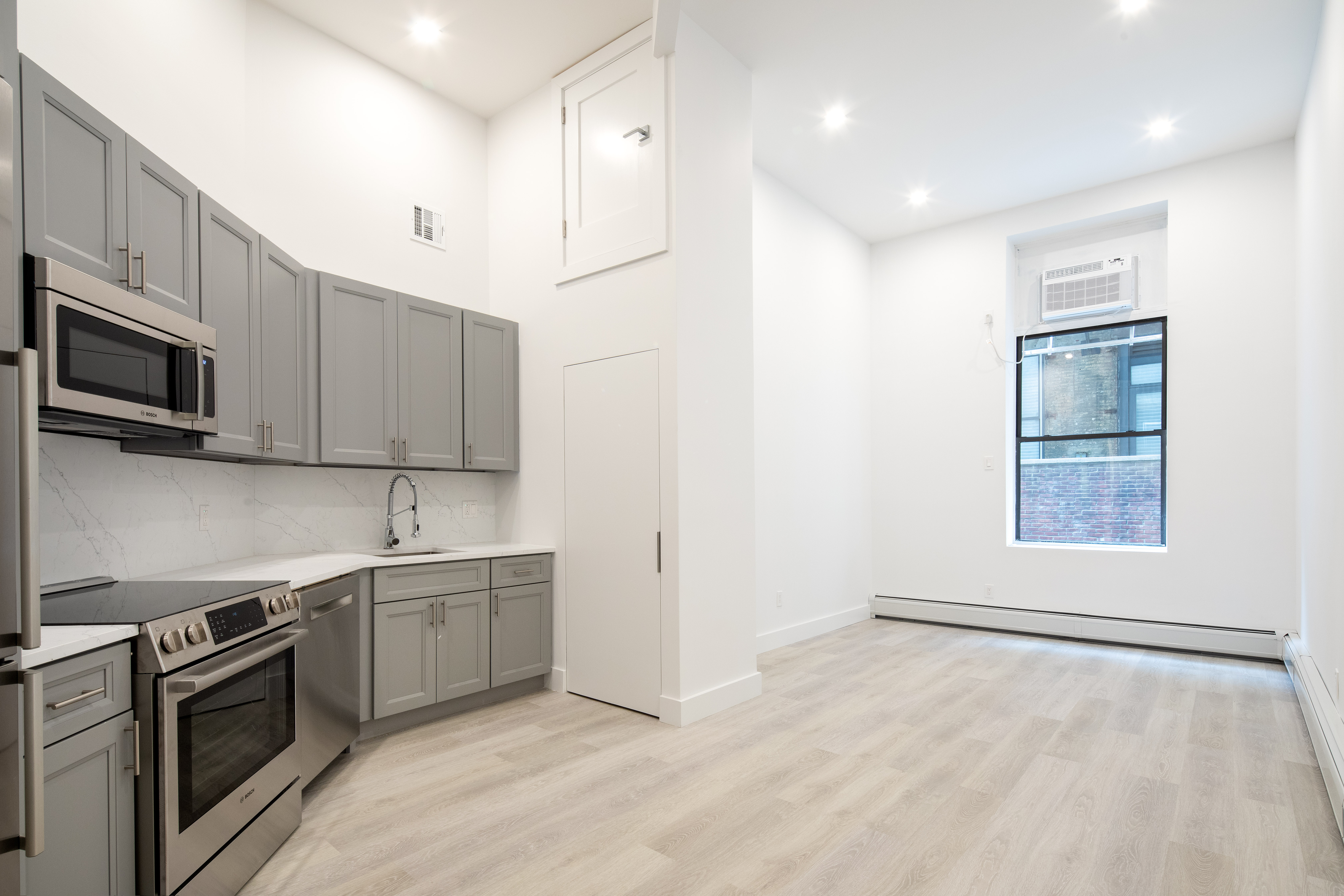 74 Leonard Street, Unit 5B Manhattan, NY 10013 - Photo 3 of 6 a kitchen with stainless steel appliances granite countertop a stove a sink and a refrigerator