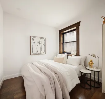 a bedroom with a bed and a window with rug