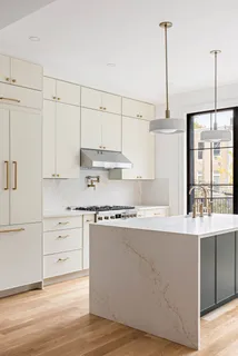 a kitchen with stainless steel appliances white cabinets and a wooden floors