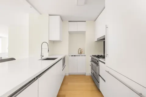 a kitchen with white cabinets appliances and a sink