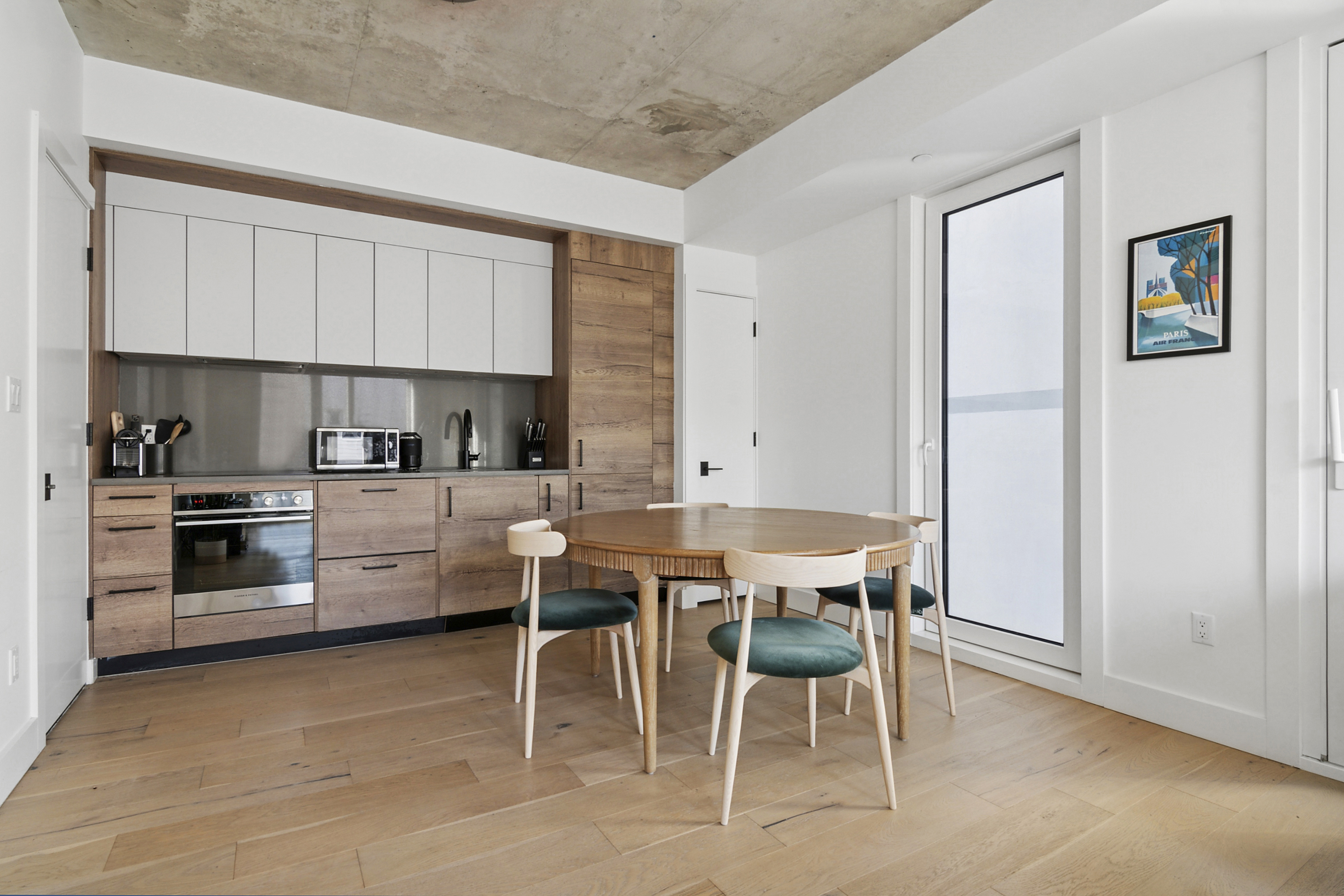 169 Huron Street, Unit 3A Brooklyn, NY 11222 - Photo 2 of 7 a kitchen with stainless steel appliances kitchen island granite countertop a table chairs sink and cabinets