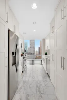 a view of a kitchen with refrigerator and cabinets