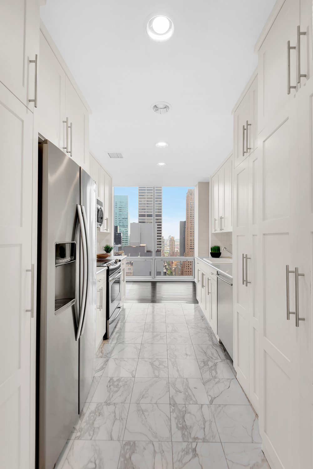 641 5th Avenue, Unit 26D Manhattan, NY 10022 - Photo 10 of 13 a view of a kitchen with refrigerator and cabinets