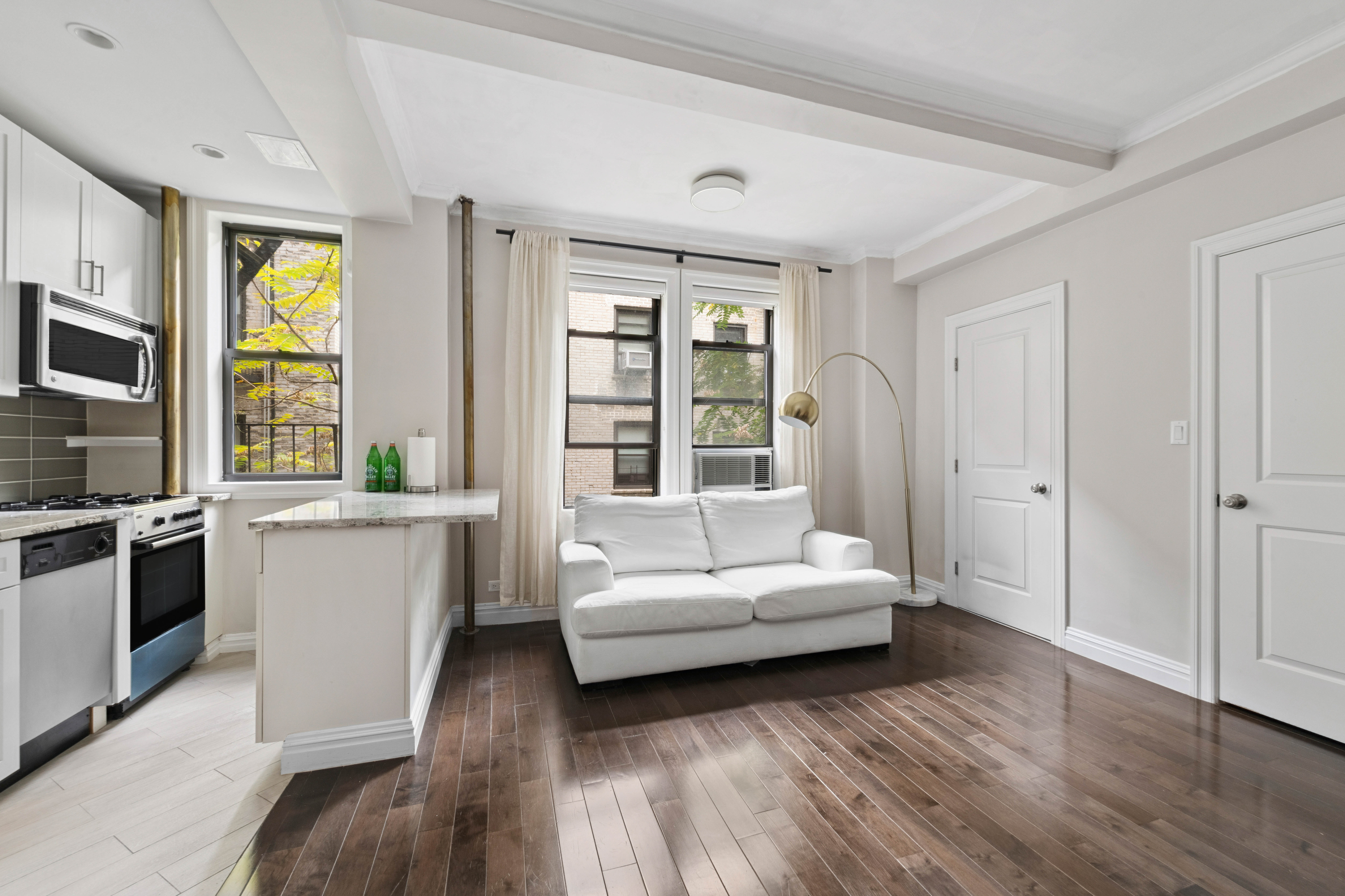 17 West 64th Street, Unit 4E Manhattan, NY 10023 - Photo 4 of 9 a living room with furniture and a large window