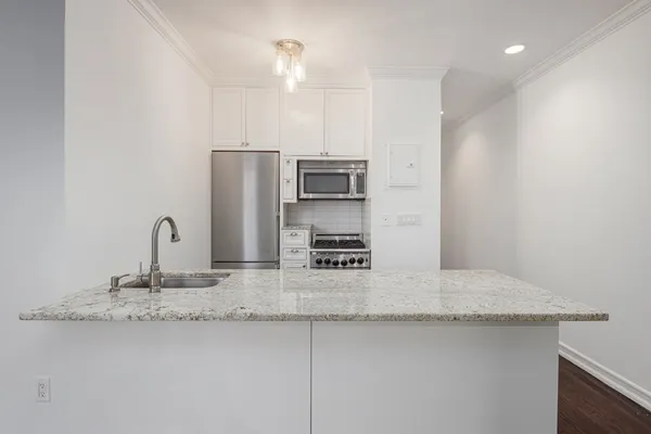 a kitchen with stainless steel appliances granite countertop a sink and a refrigerator