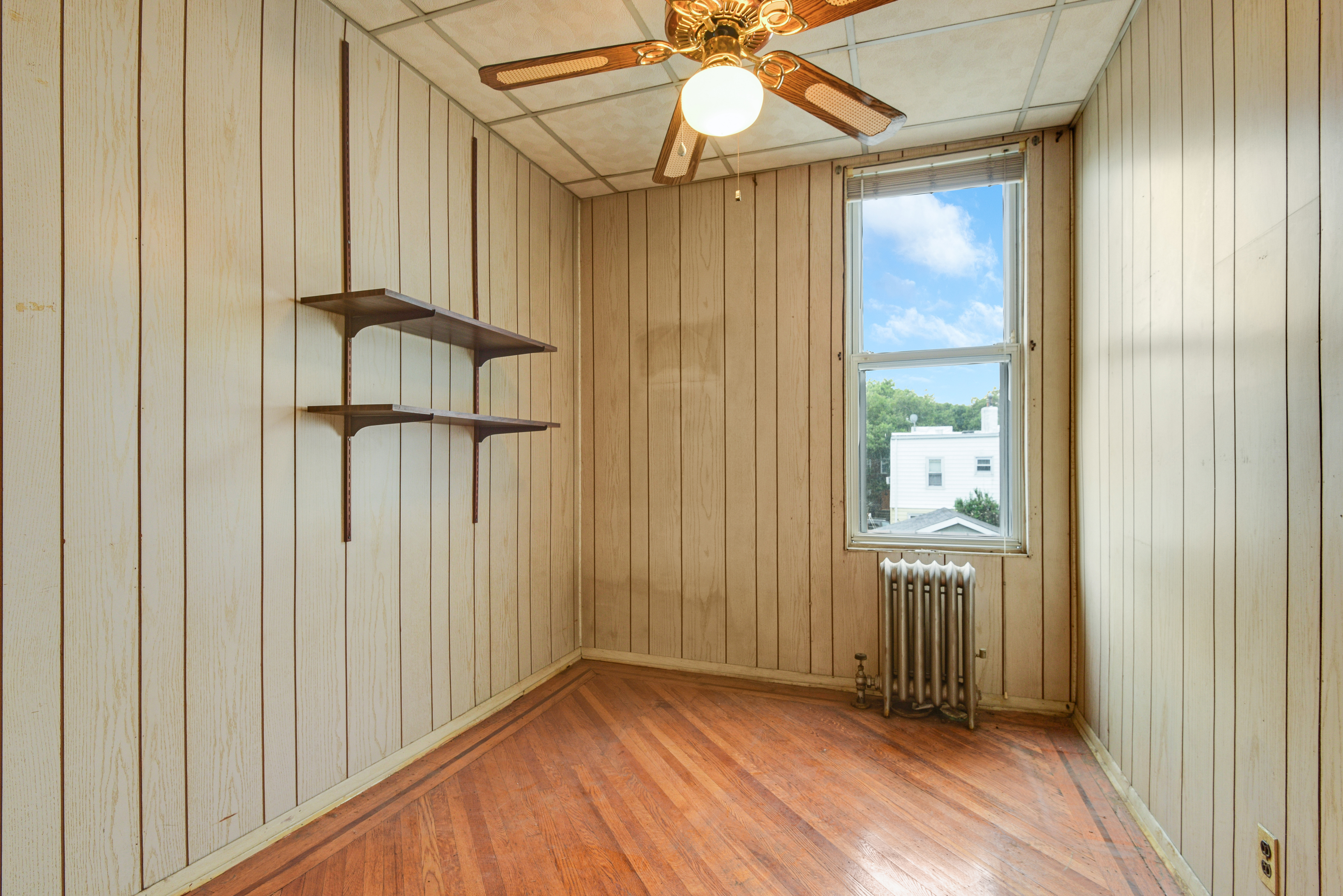 75-36 60th Lane Queens, NY 11385 - Photo 12 of 18 a view of empty room with wooden floor and fan