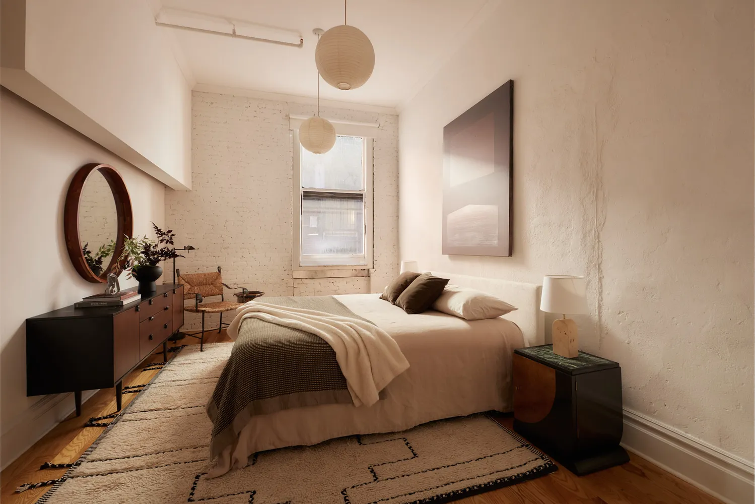 a bedroom with a bed and a large mirror with a large window