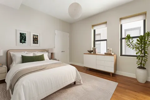 a bedroom with a large bed and a potted plant