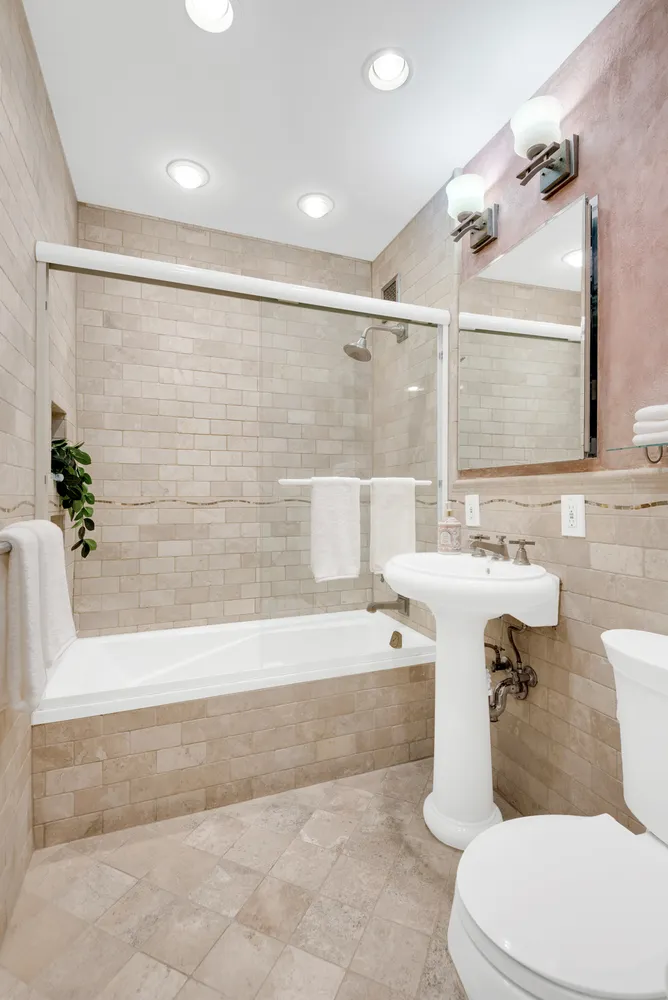 a bathroom with a sink a mirror a toilet and bathtub