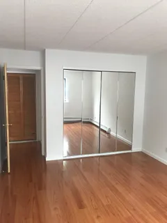 an empty room with wooden floor and door