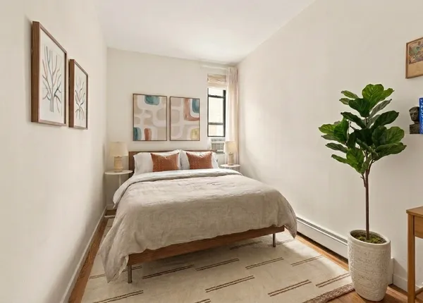 a bedroom with a bed and a potted plant