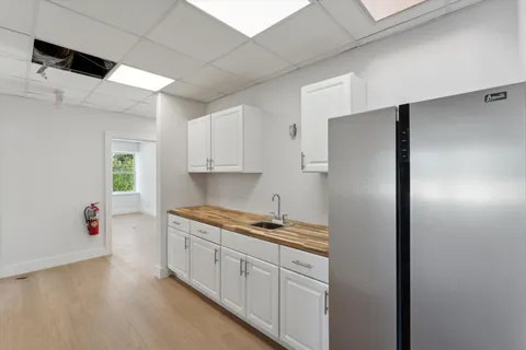 a kitchen with a refrigerator and a stove top oven