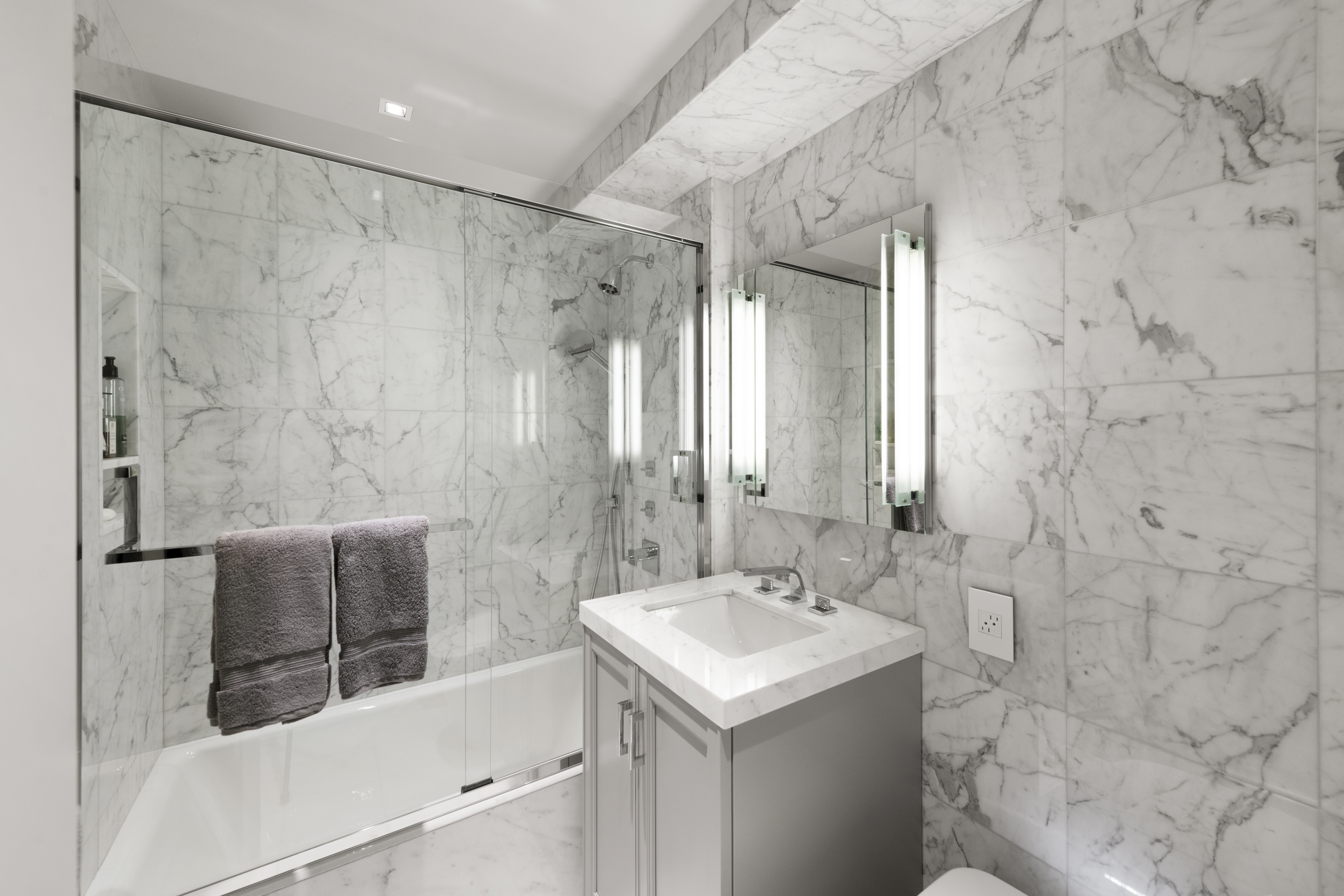 180 East End Avenue, Unit 15E Manhattan, NY 10128 - Photo 10 of 31 a bathroom with a sink and a mirror