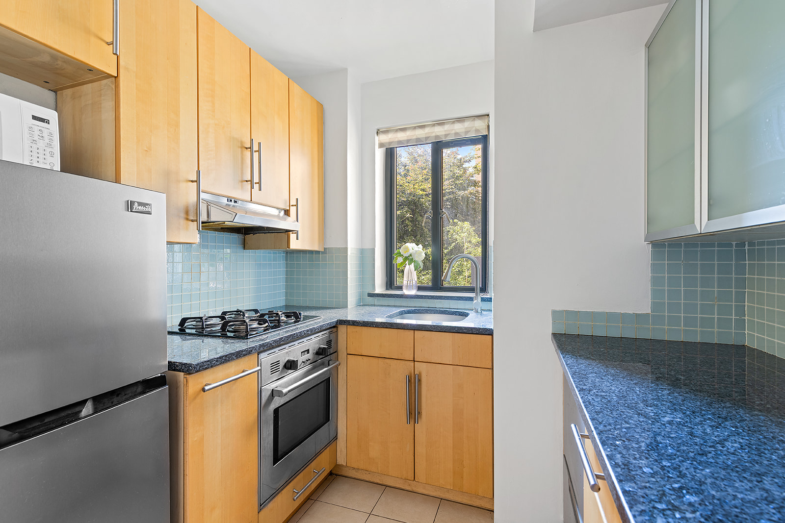 100 Remsen Street, Unit 3C Brooklyn, NY 11201 - Photo 4 of 10 a kitchen with stainless steel appliances granite countertop a stove a sink and a microwave