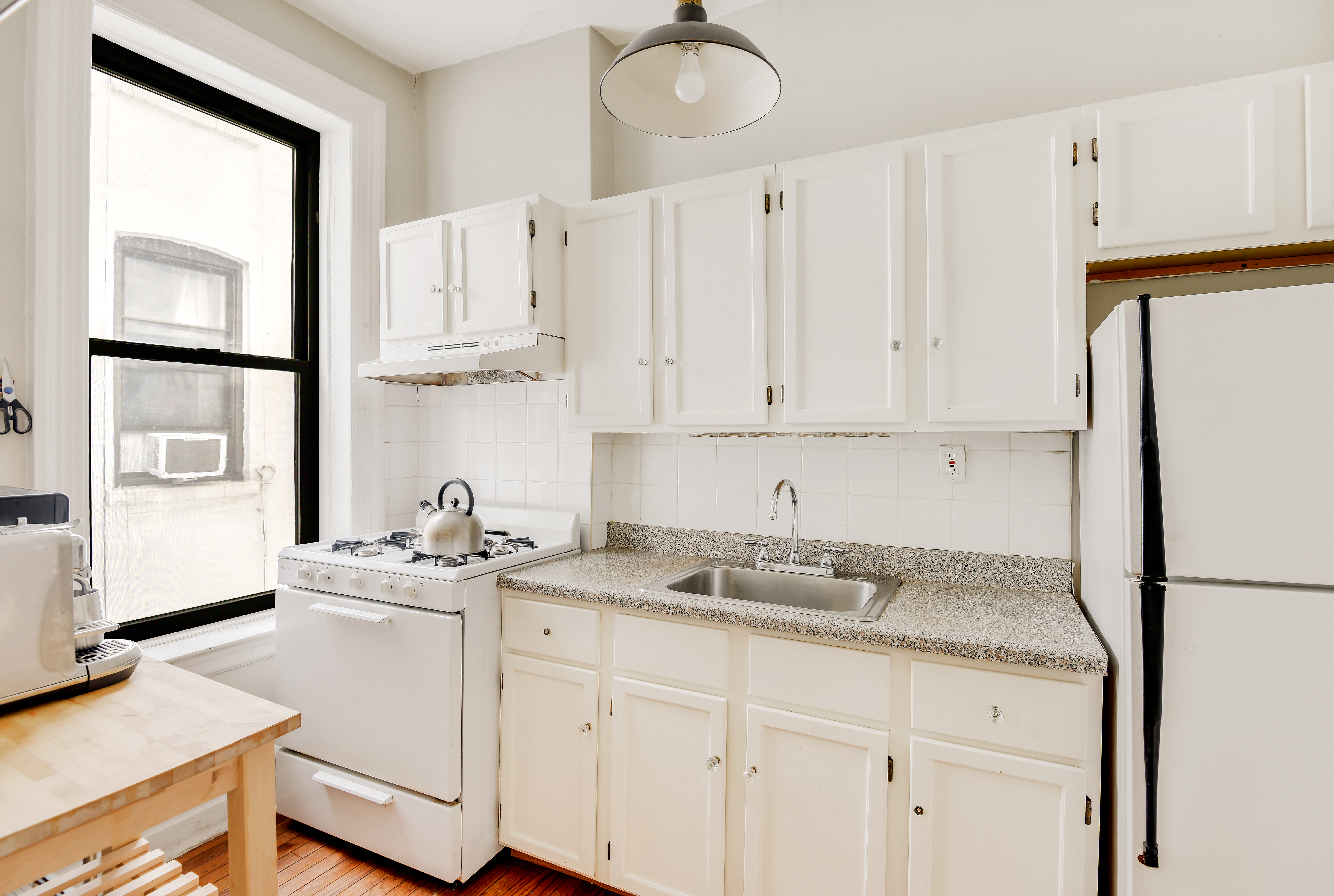 408 8th Avenue, Unit 3B Brooklyn, NY 11215 - Photo 3 of 5 a kitchen with granite countertop white cabinets and white appliances