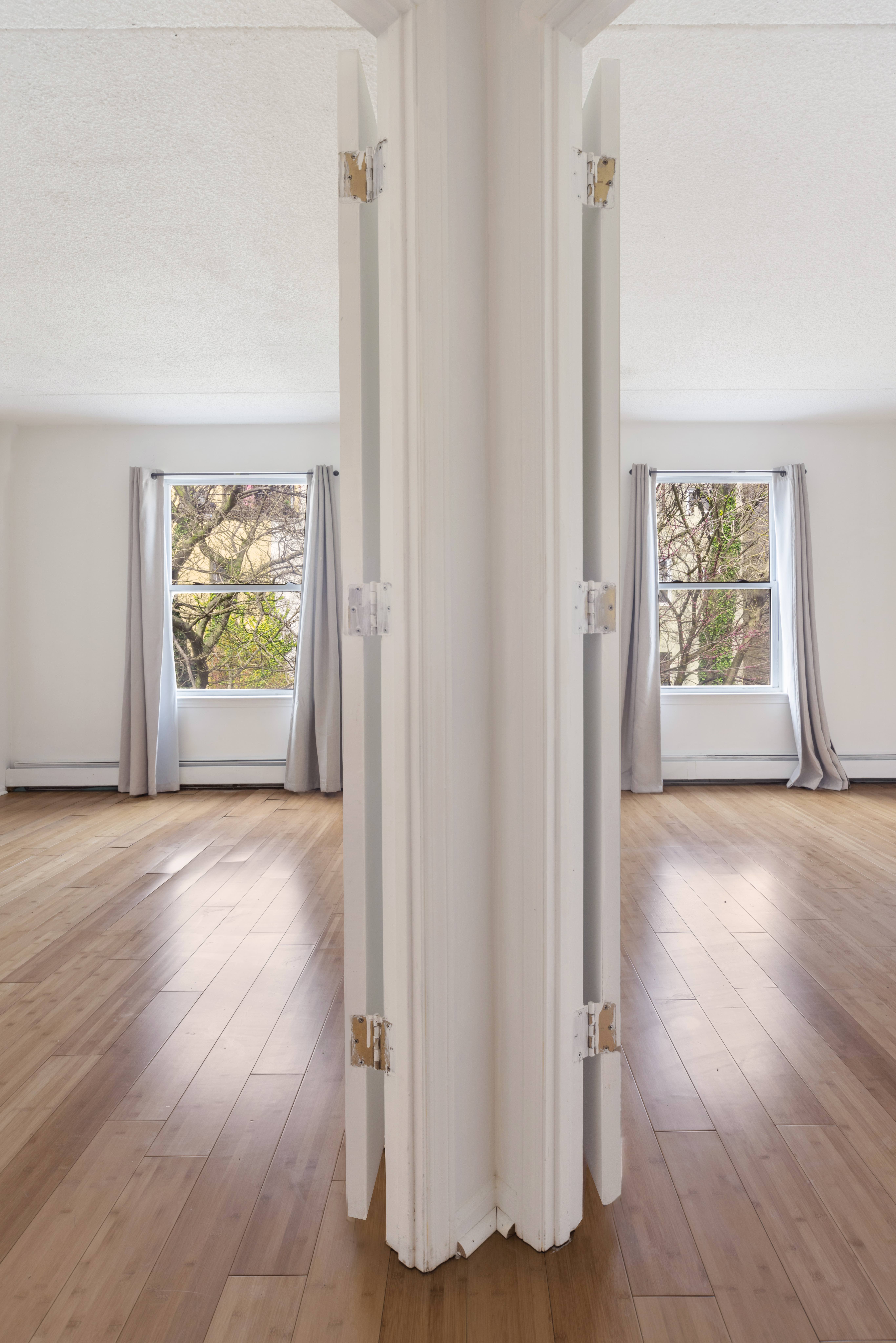 125 West 117th Street Manhattan, NY 10026 - Photo 20 of 23 an empty room with wooden floor window and ceiling fan