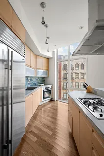 a kitchen with stainless steel appliances a refrigerator a stove and wooden floor
