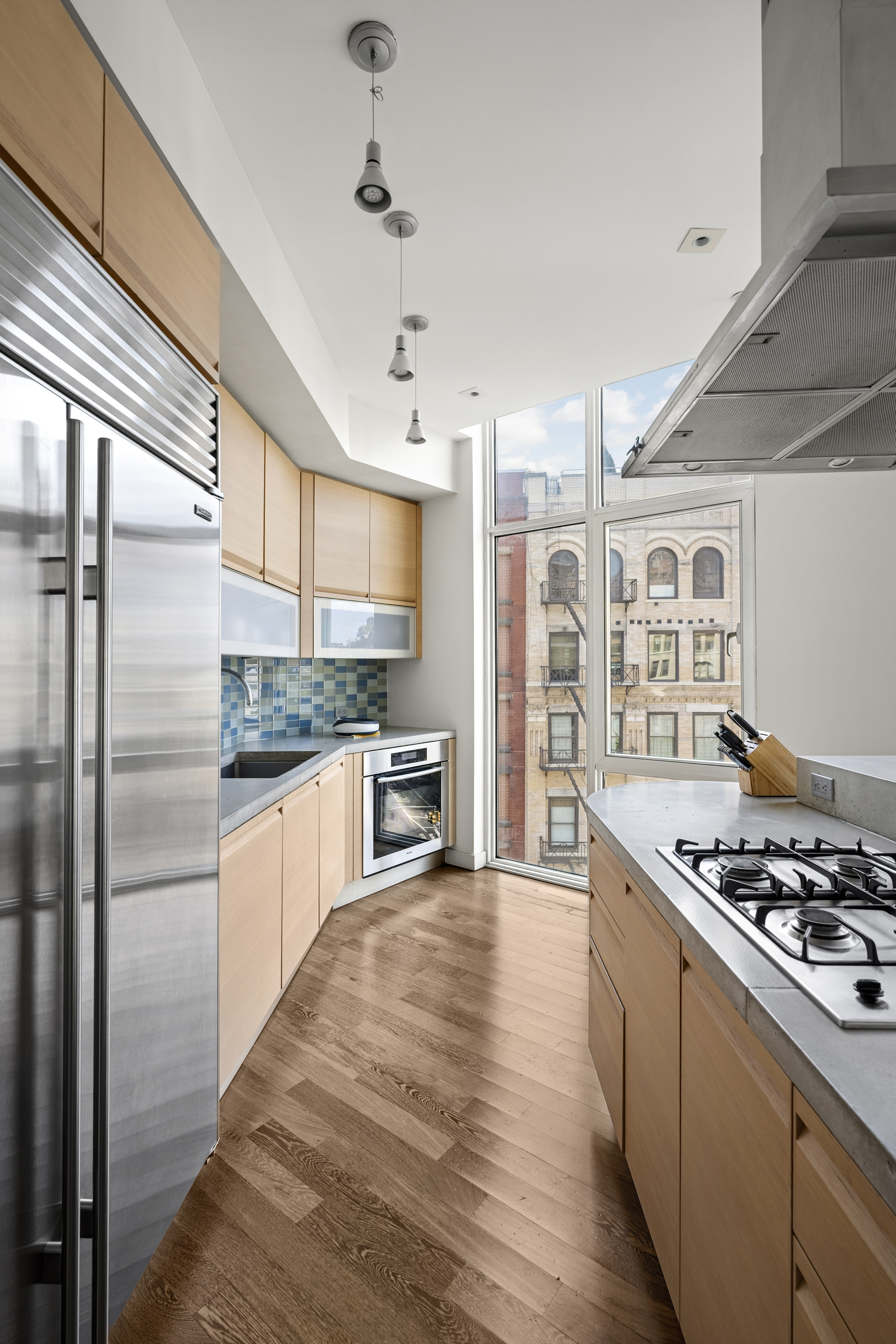 475 Greenwich Street, Unit 5B Manhattan, NY 10013 - Photo 2 of 16 a kitchen with stainless steel appliances a refrigerator a stove and wooden floor
