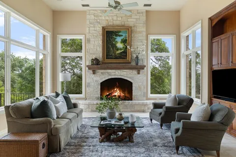 a living room with furniture a fireplace and a large window