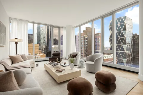 a living room with furniture and a floor to ceiling window
