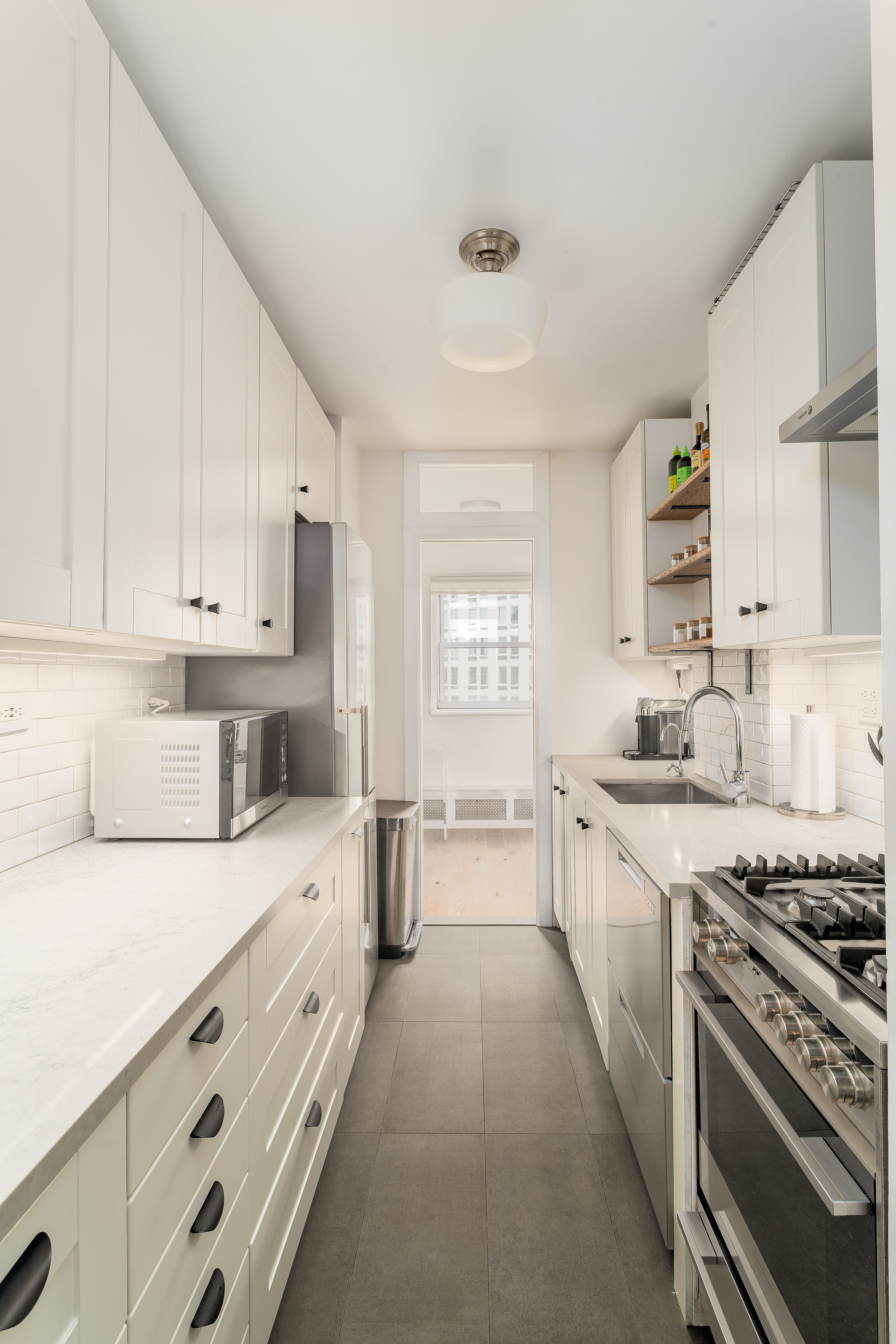 191 Willoughby Street, Unit 12J Brooklyn, NY 11201 - Photo 9 of 19 a kitchen with granite countertop a sink stove and cabinets