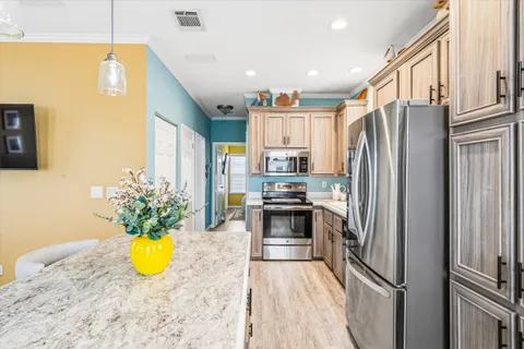 a kitchen with stainless steel appliances granite countertop a refrigerator a stove and a window