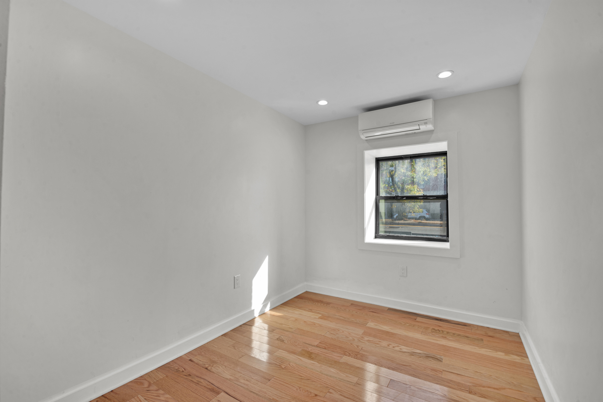 31 Roosevelt Place, Unit 1A Brooklyn, NY 11233 - Photo 8 of 14 an empty room with wooden floor and windows