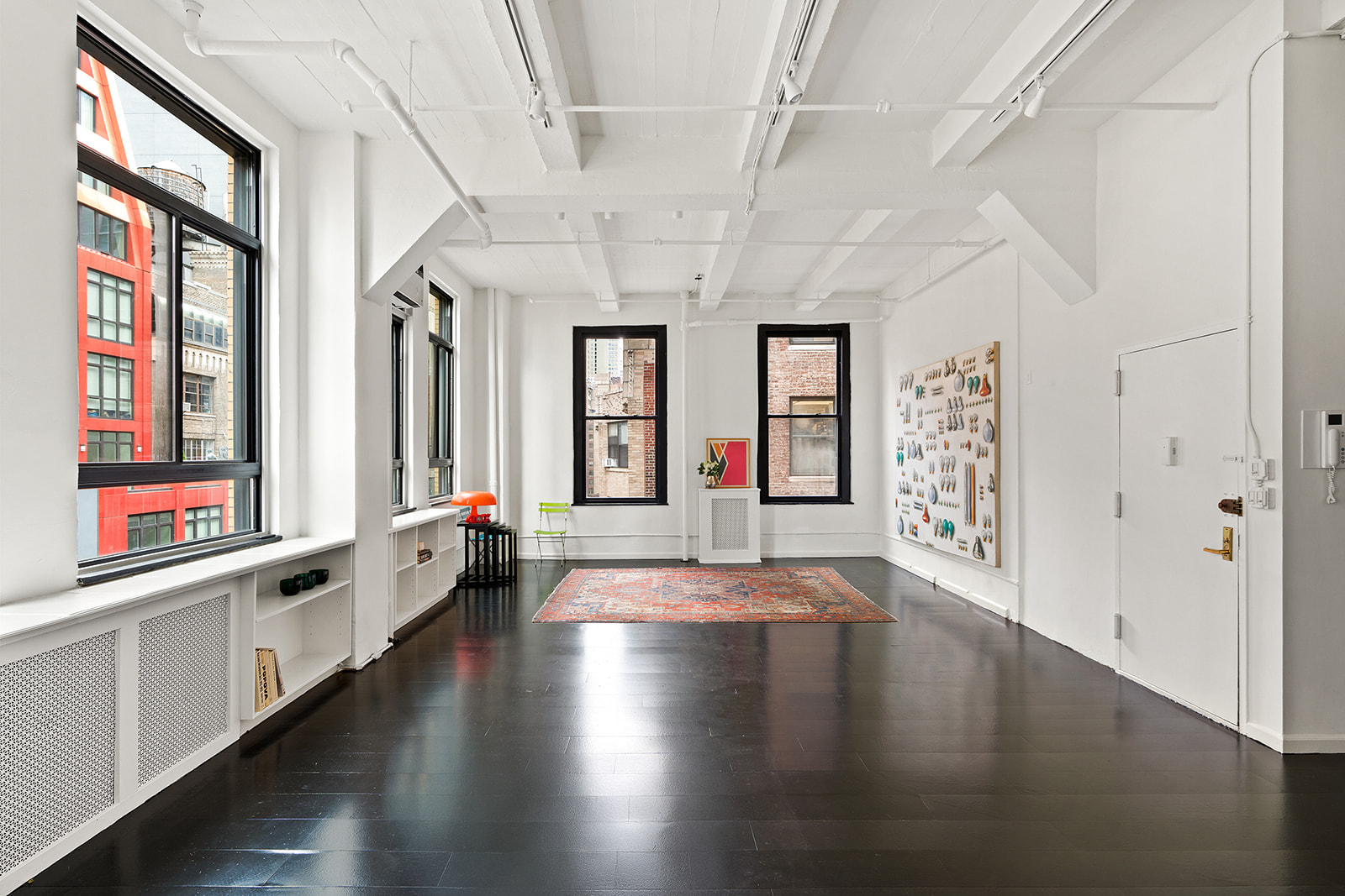 348 West 38th Street, Unit 9E Manhattan, NY 10018 - Photo 3 of 10 an empty room with wooden floor and windows