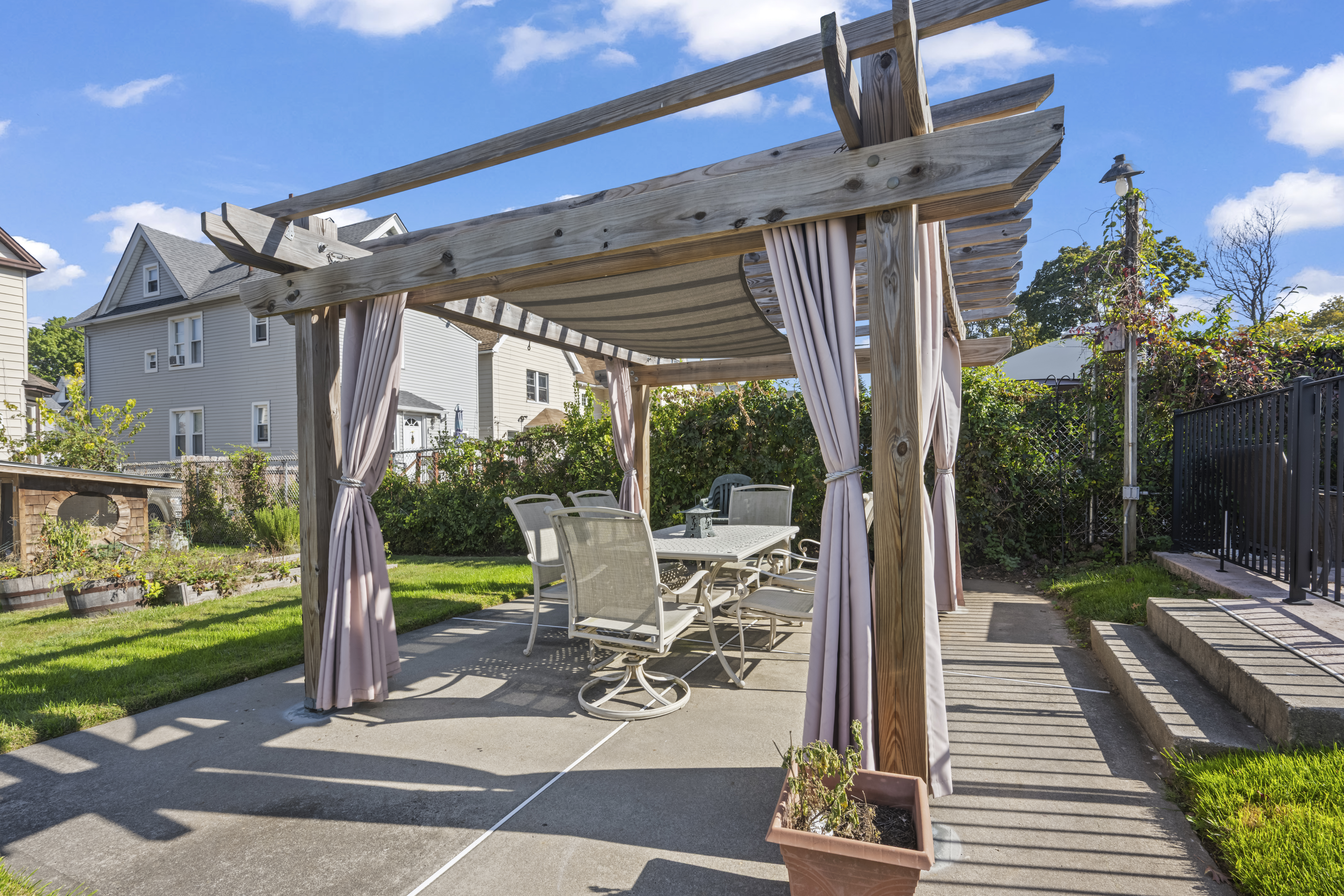 704 Delafield Avenue Staten Island, NY 10310 - Photo 25 of 35 a view of a patio with table and chairs potted plants and palm trees