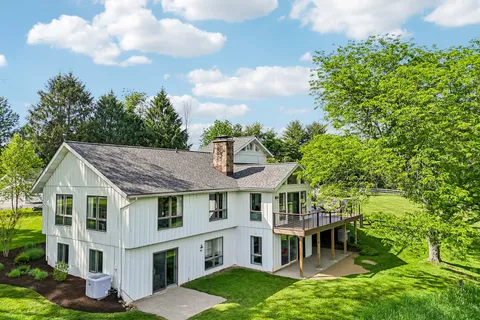 a aerial view of a house with a yard table and chairs