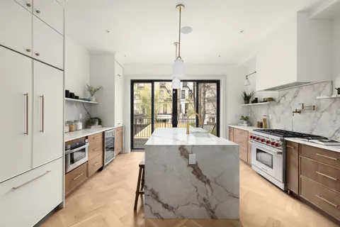 a large kitchen with stainless steel appliances granite countertop a stove and refrigerator