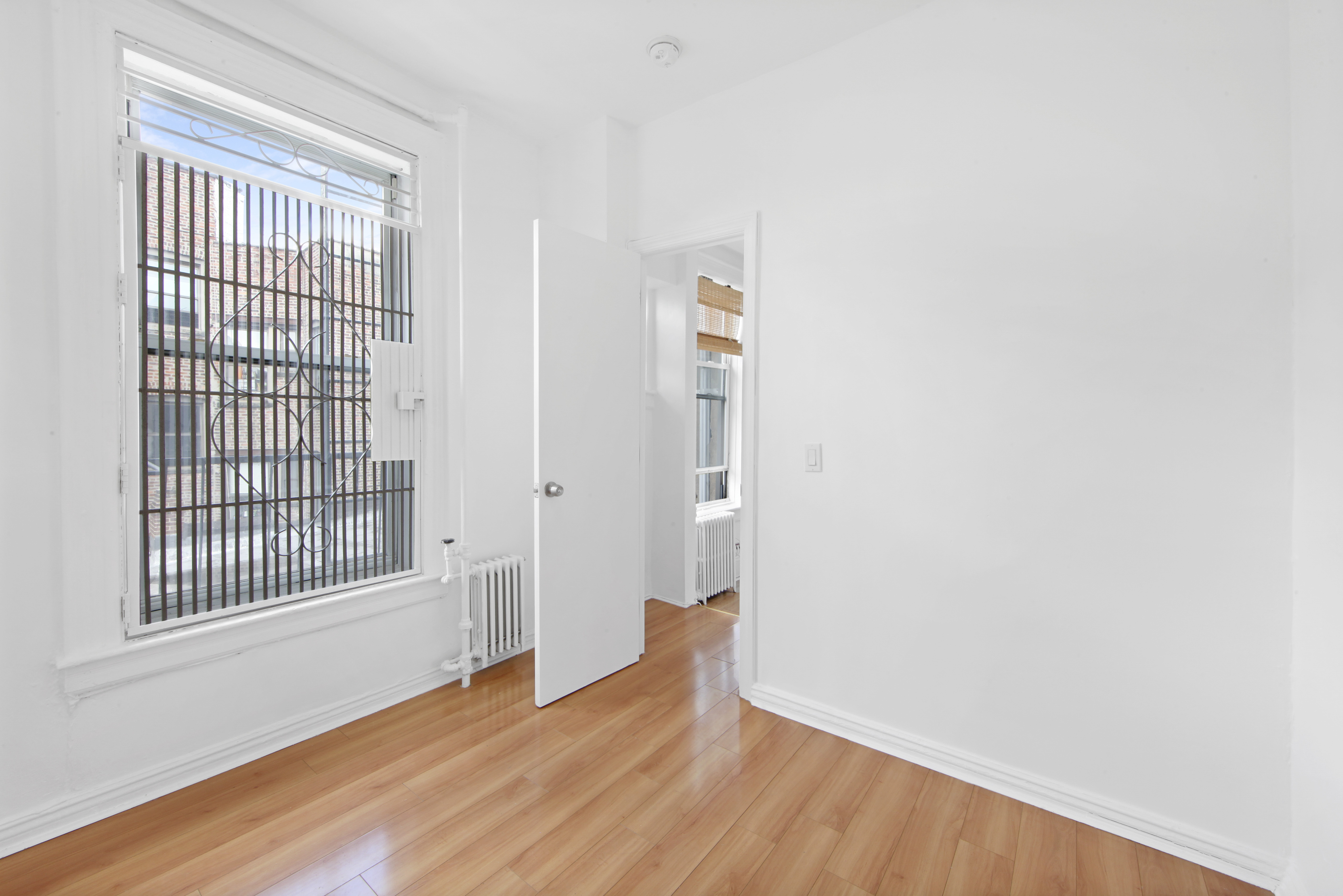 150 Sullivan Street, Unit 37 Manhattan, NY 10012 - Photo 9 of 12 a view of an empty room with wooden floor and a window