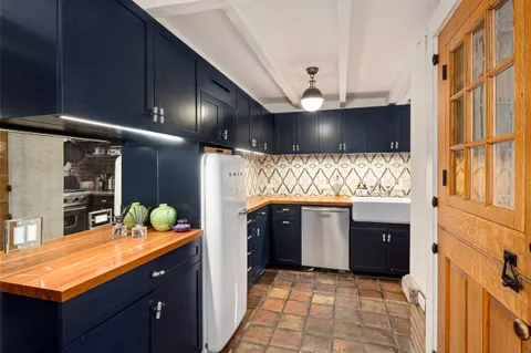 a kitchen with granite countertop a sink stainless steel appliances a counter space and wooden floor