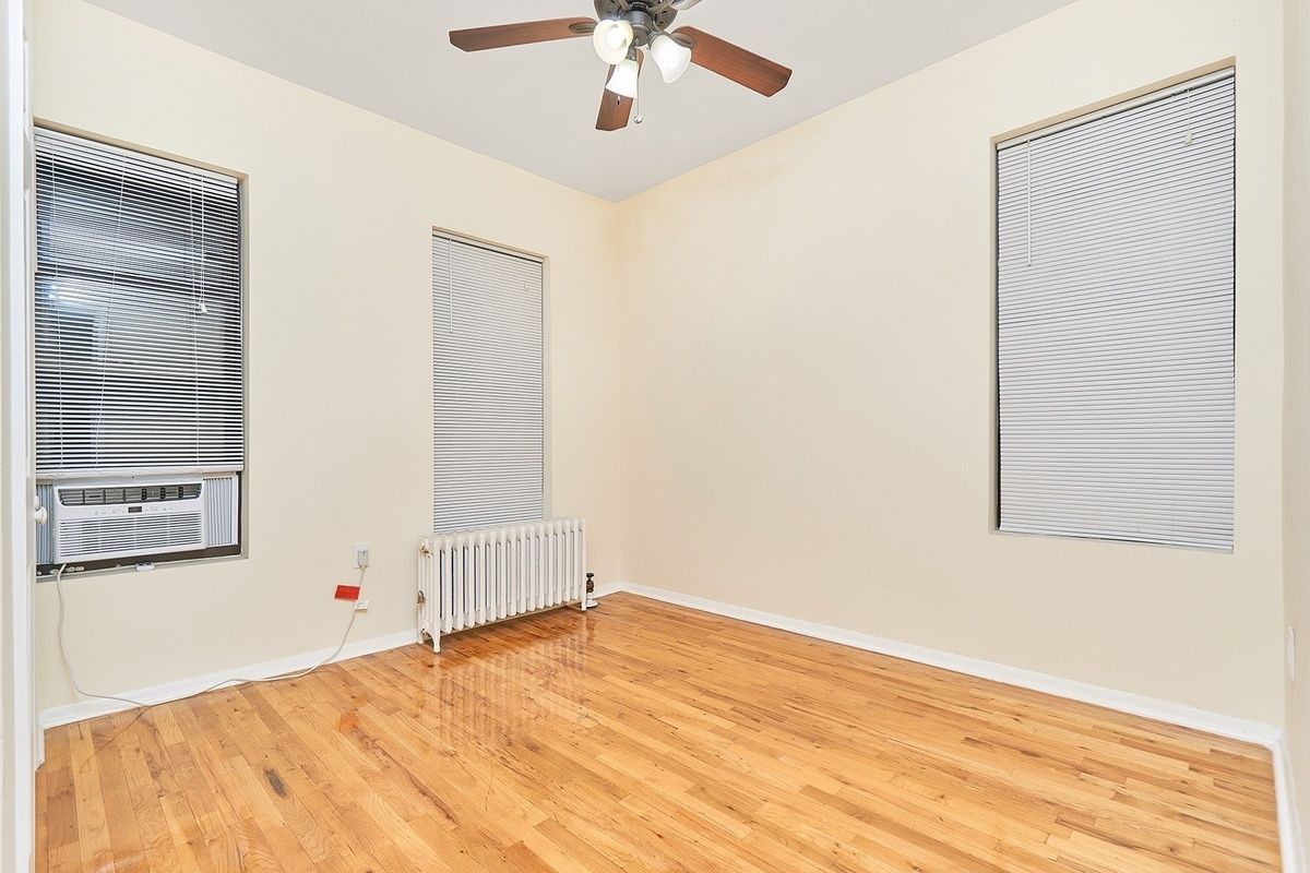 270 East 78th Street, Unit 12 Manhattan, NY 10075 - Photo 4 of 6 an empty room with a ceiling fan and wooden floor