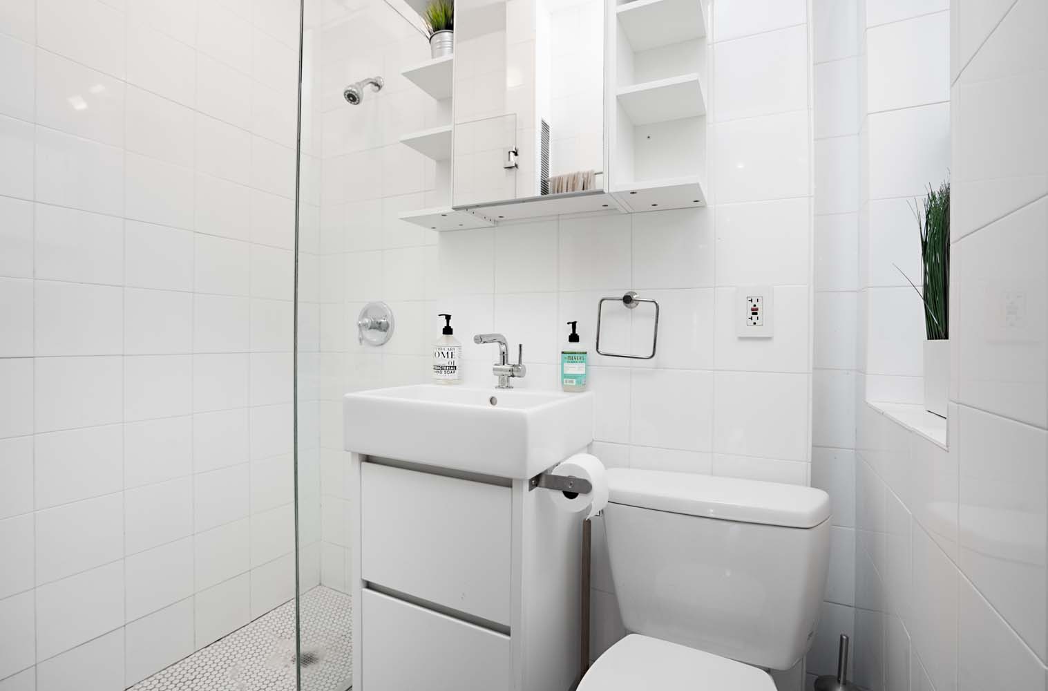 218 East 82nd Street, Unit 4FW Manhattan, NY 10028 - Photo 8 of 9 a bathroom with a sink a toilet and shower
