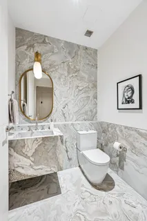 a bathroom with a toilet sink and mirror